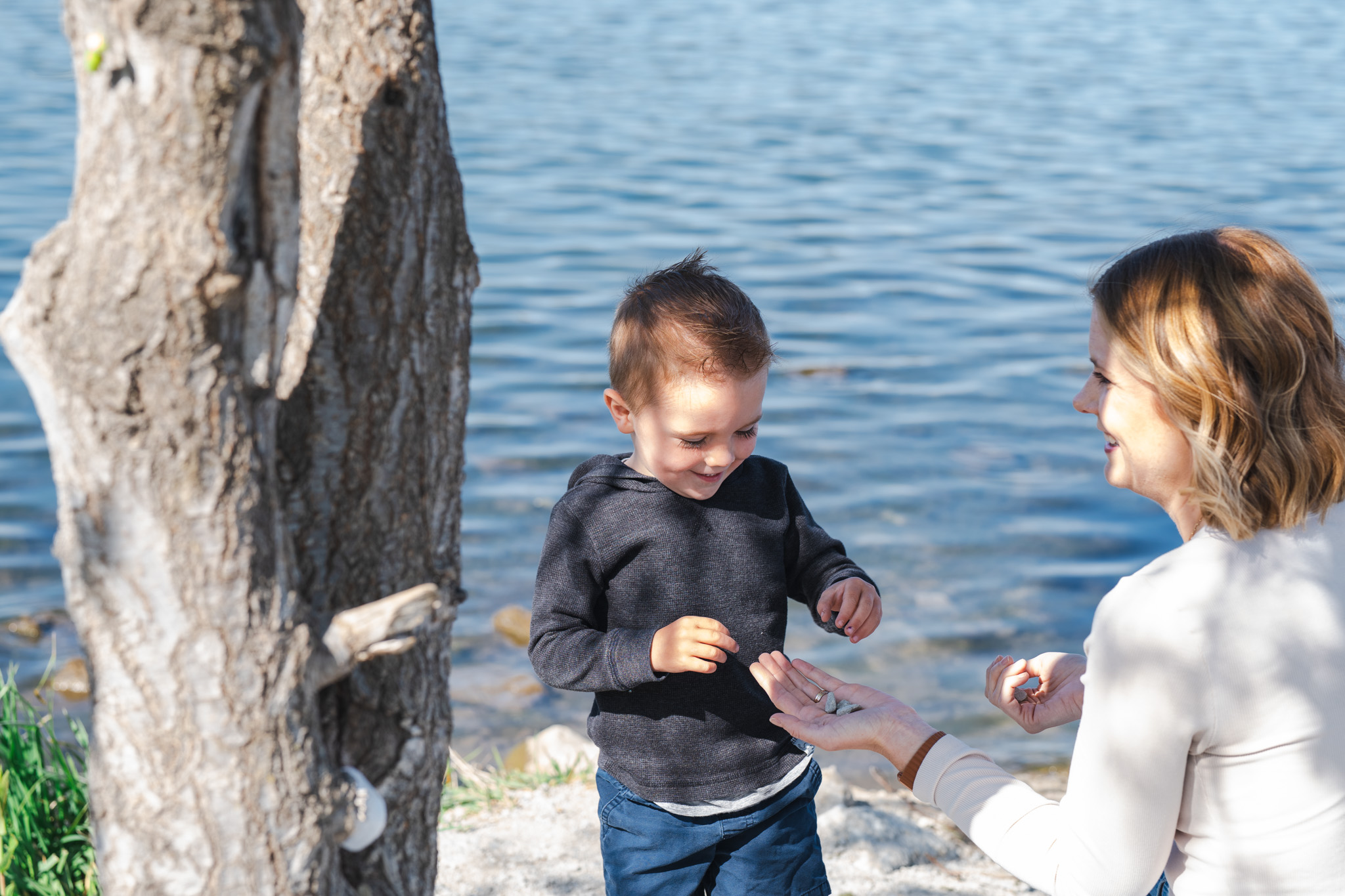 Omaha family photography — mother and toddler son exploring rocks by the water